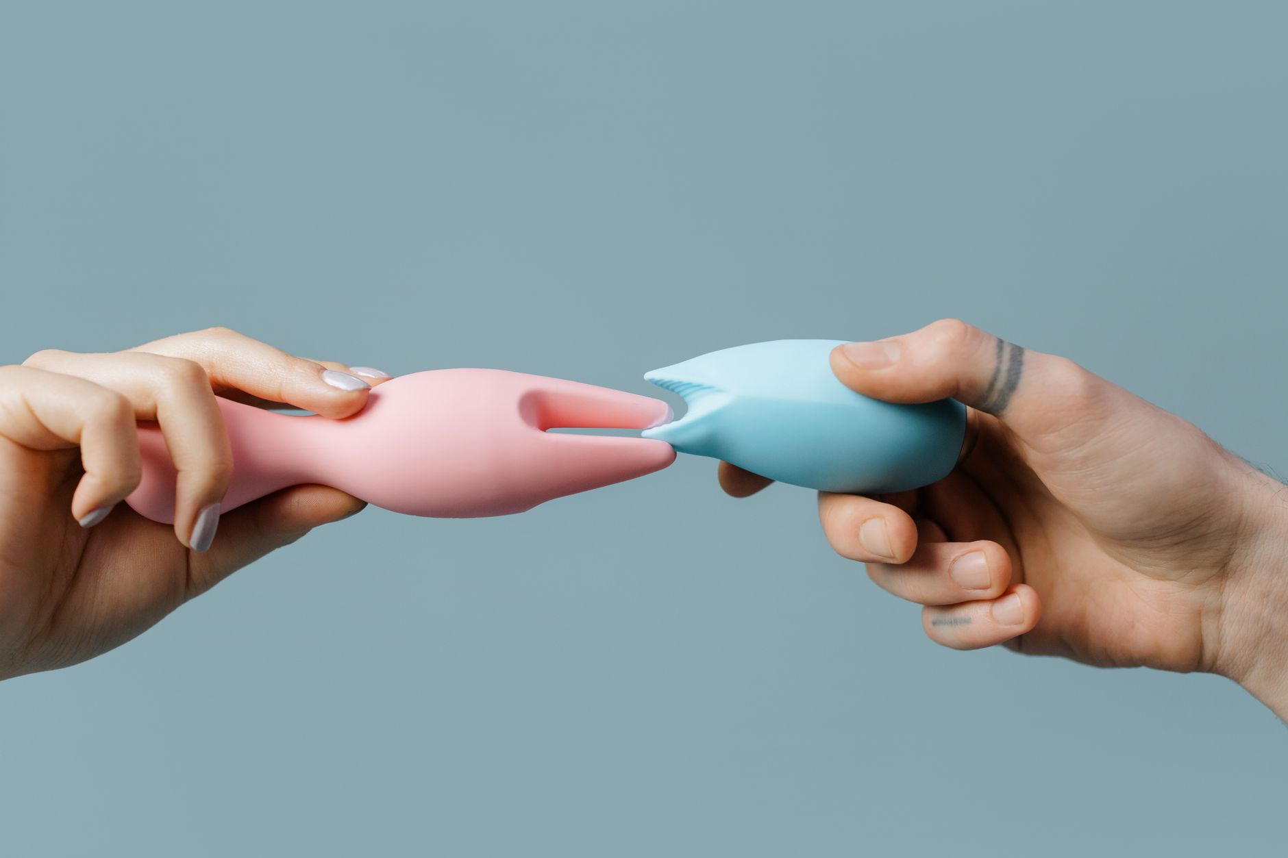 Close-up array of vibrant silicone vibrators in jewel tones on neutral background